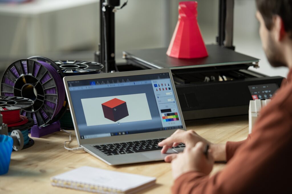 Creative designer working over new 3d model on laptop screen before printing